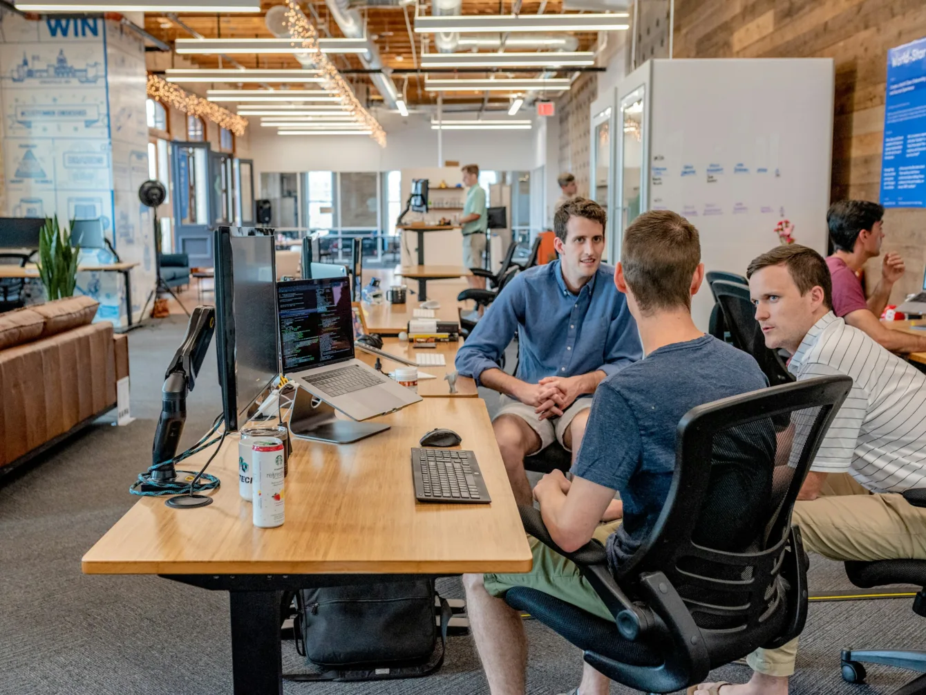 A team talking together around desks in an open-plan office